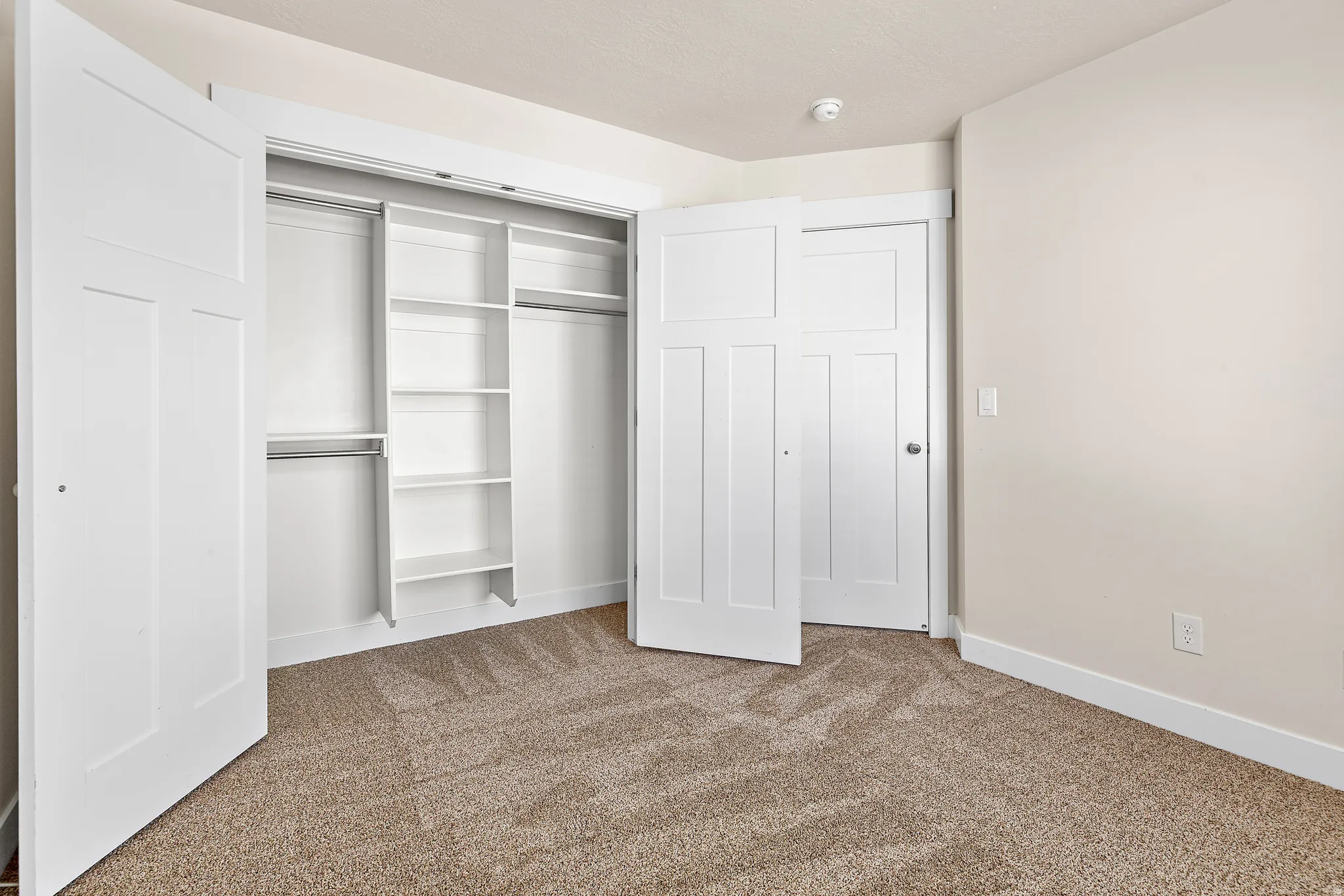 Unfurnished bedroom with light colored carpet and a closet