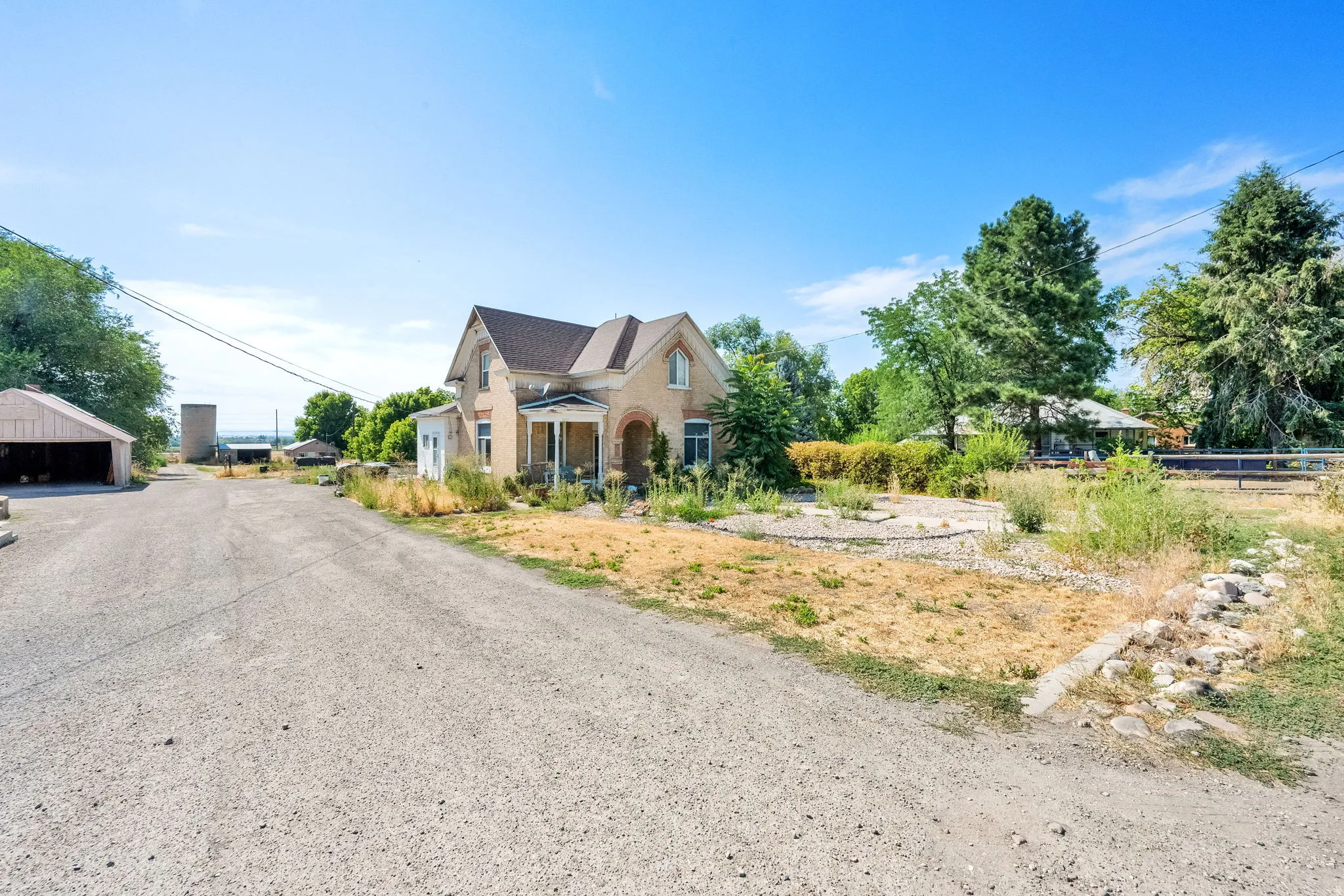 View of front facade featuring brick siding and a detached garage