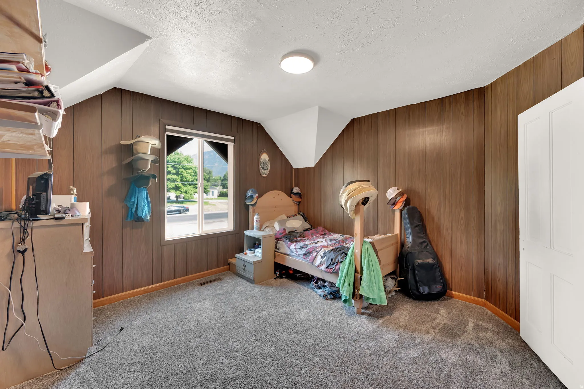 Bedroom featuring wood walls and light colored carpet