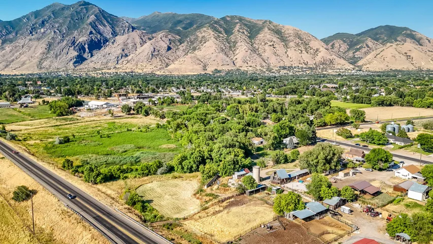 Aerial view of property and surrounding area with a mountain backdrop