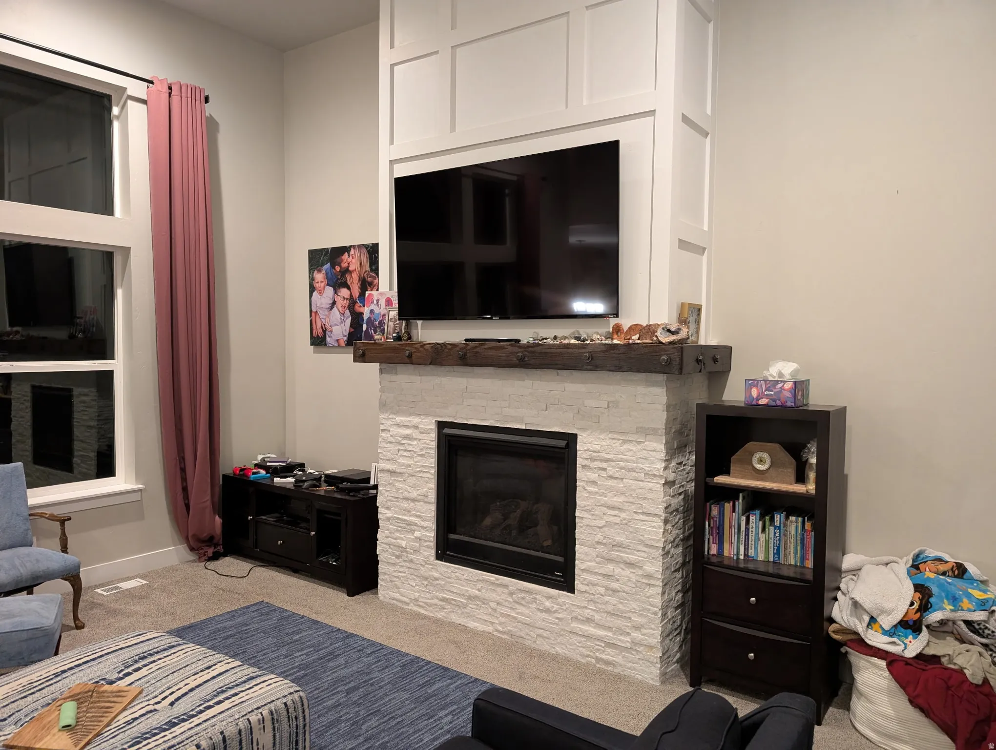 Living area with a fireplace and light colored carpet