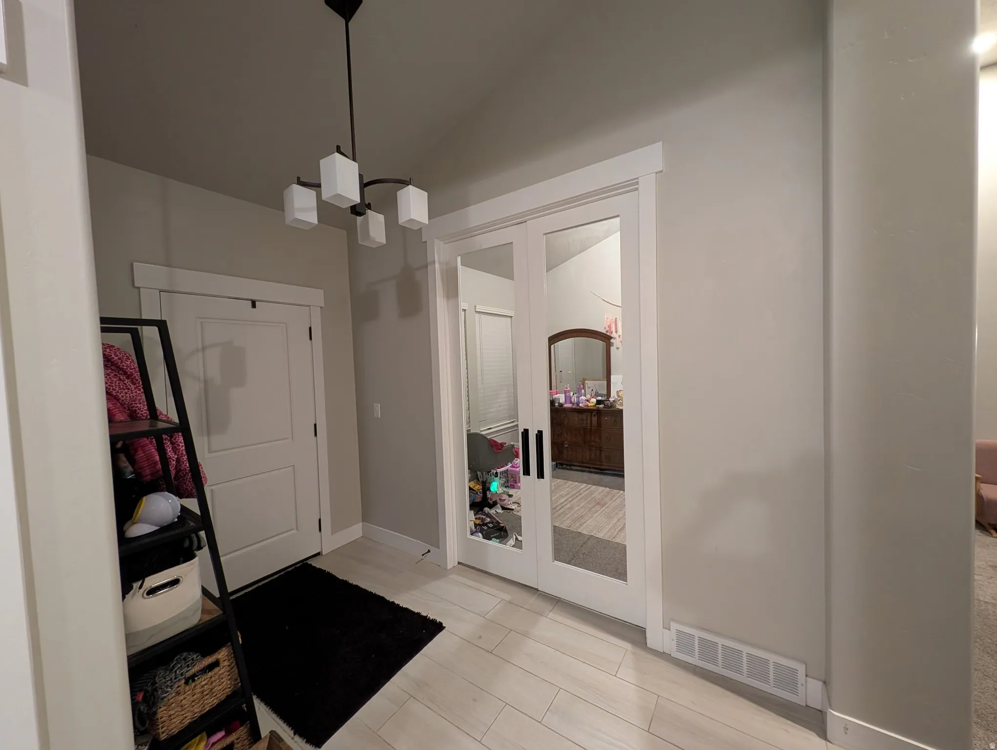 Entryway with wood tiled floors, french doors, vaulted ceiling, and suspended lighting