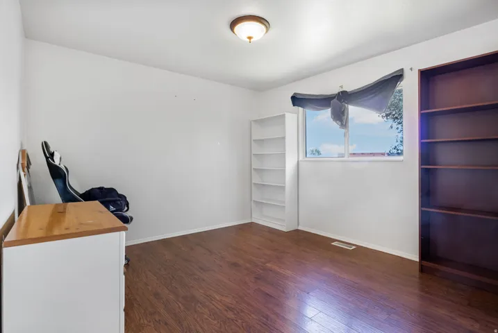 Unfurnished office with baseboards and dark wood-style flooring