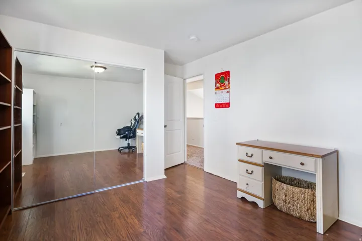 Unfurnished office featuring dark wood-style flooring and baseboards