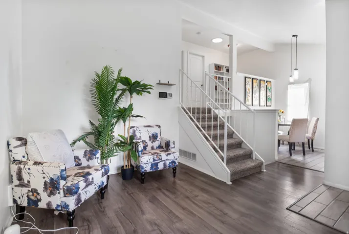 Staircase with wood finished floors and beamed ceiling