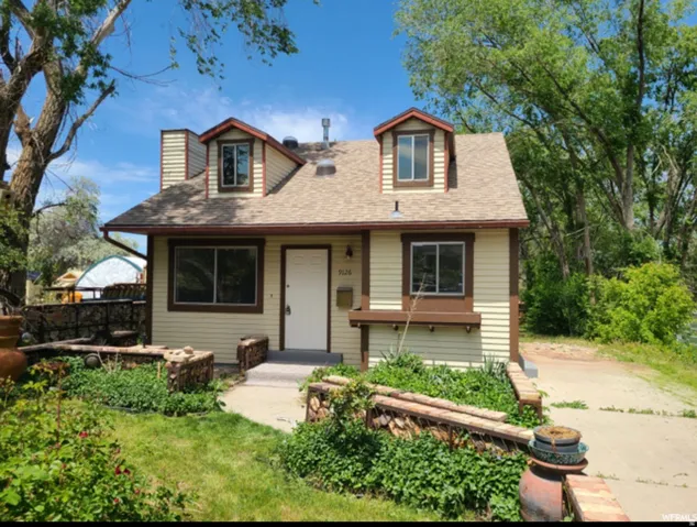 View of front of home featuring roof with shingles