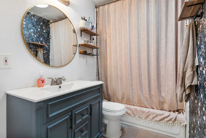Full bath featuring vanity and curtained shower