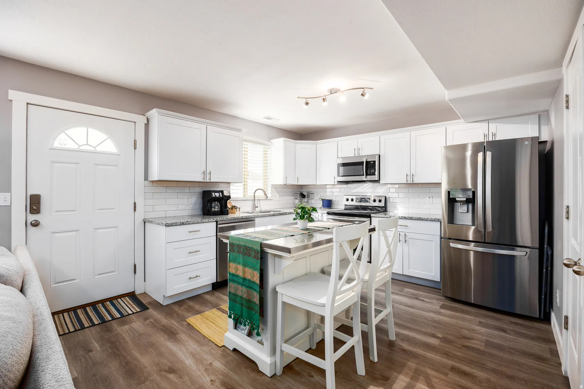 Kitchen featuring white cabinets, stainless steel appliances, and a kitchen island