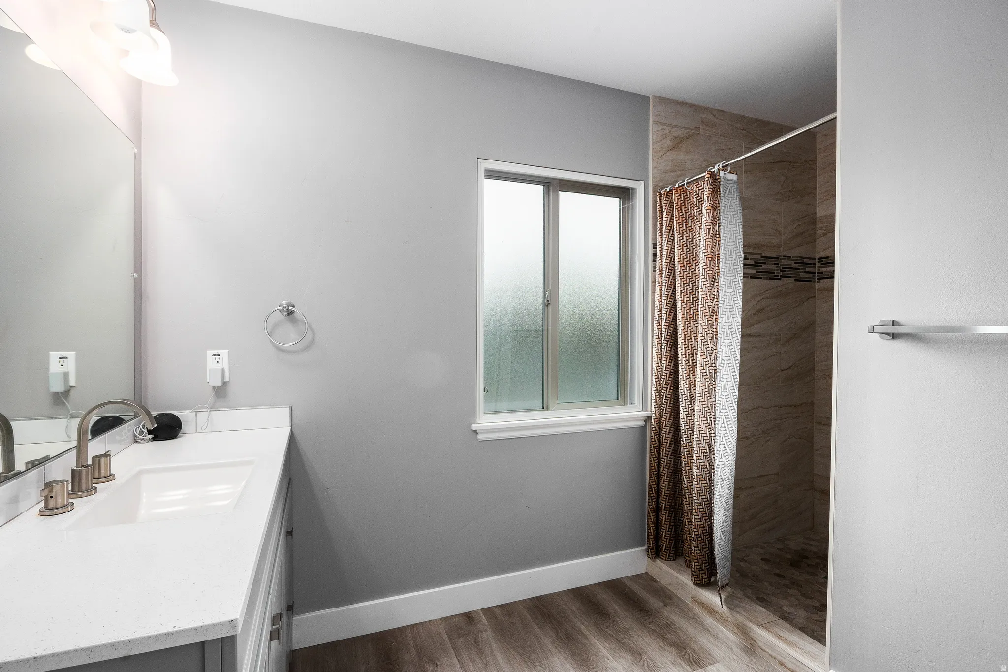 Primary ensuite featuring a shower stall, vanity, and LVP flooring