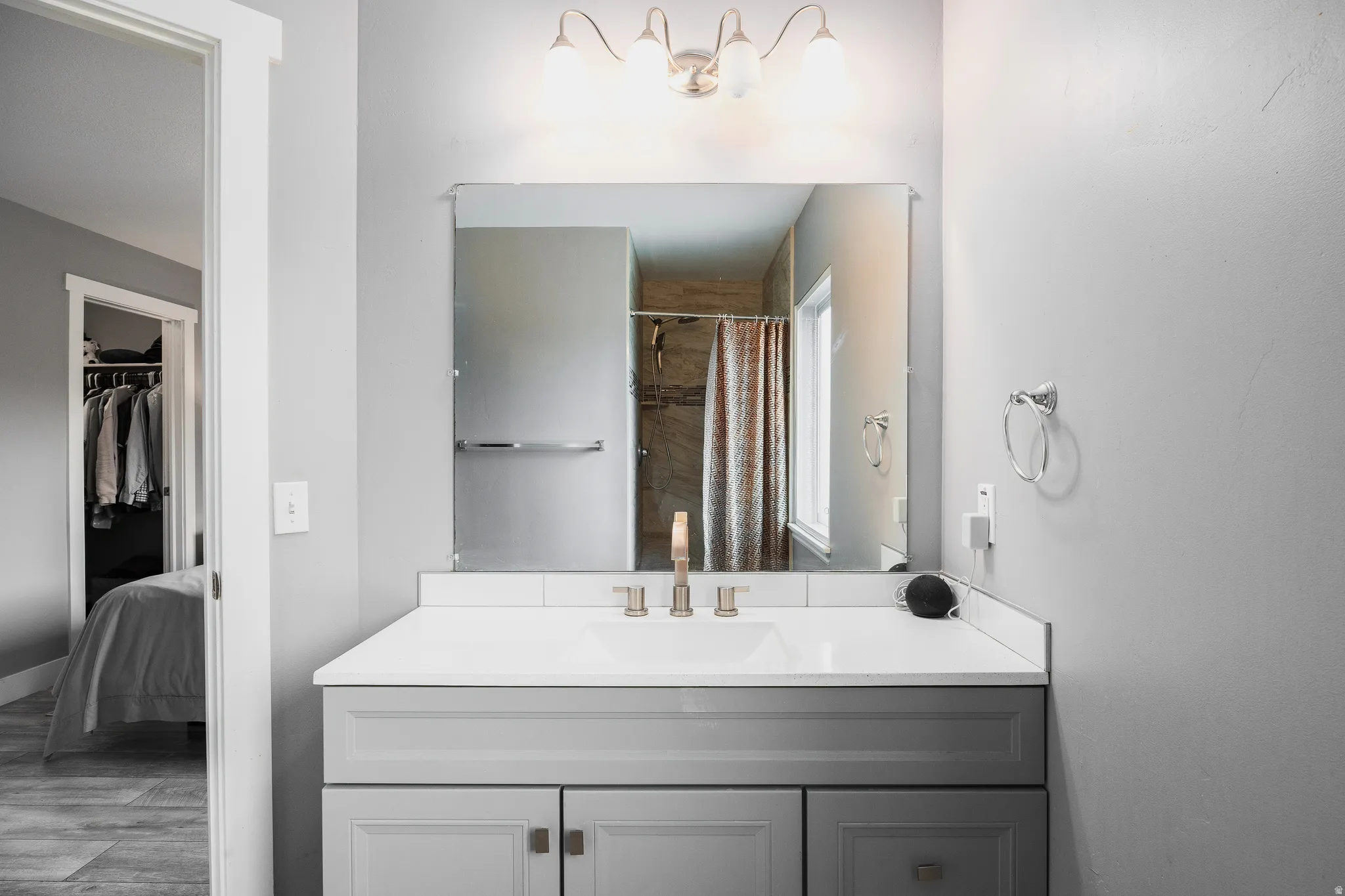 Primary ensuite featuring a shower stall, vanity, and LVP flooring