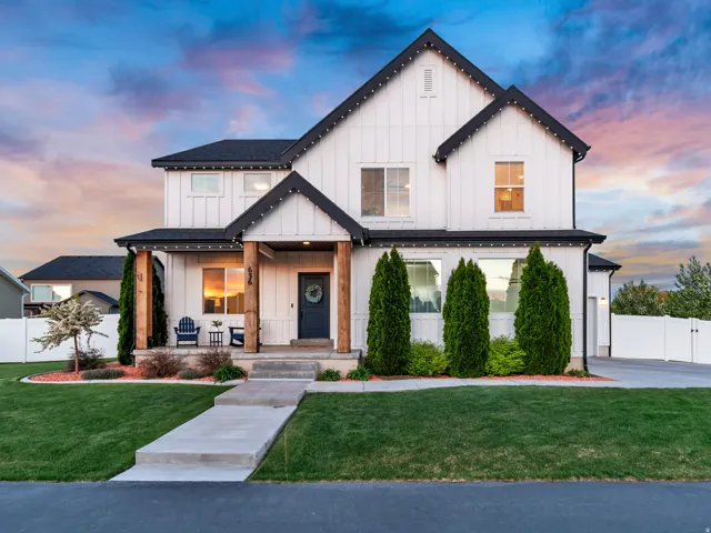Charming modern farmhouse featuring board and batten siding, covered porch, and side-load garage