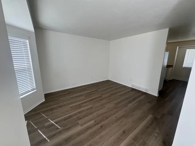 Unfurnished room with dark wood finished floors and a textured ceiling