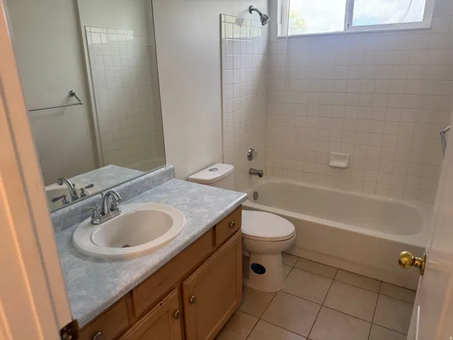 Full bath with vanity, washtub / shower combination, and light tile patterned floors