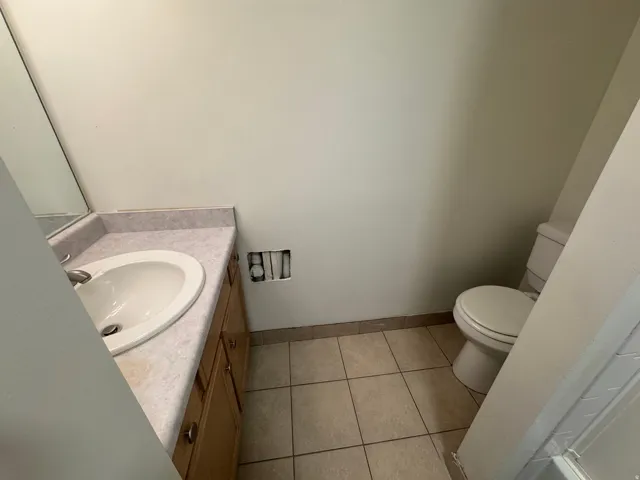 Half bath with vanity and light tile patterned floors