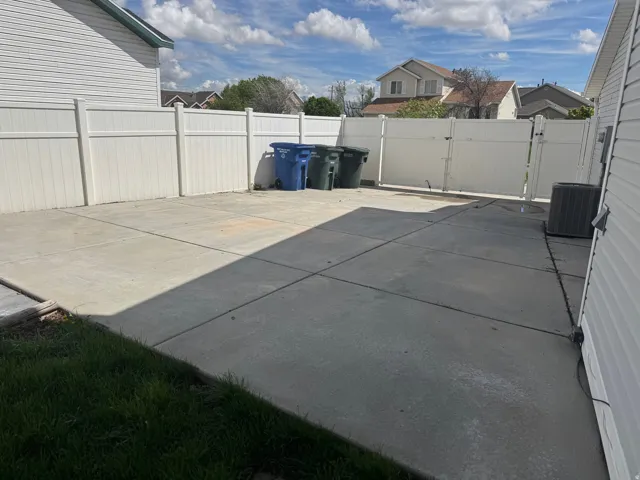 Fenced backyard featuring a patio area and a gate