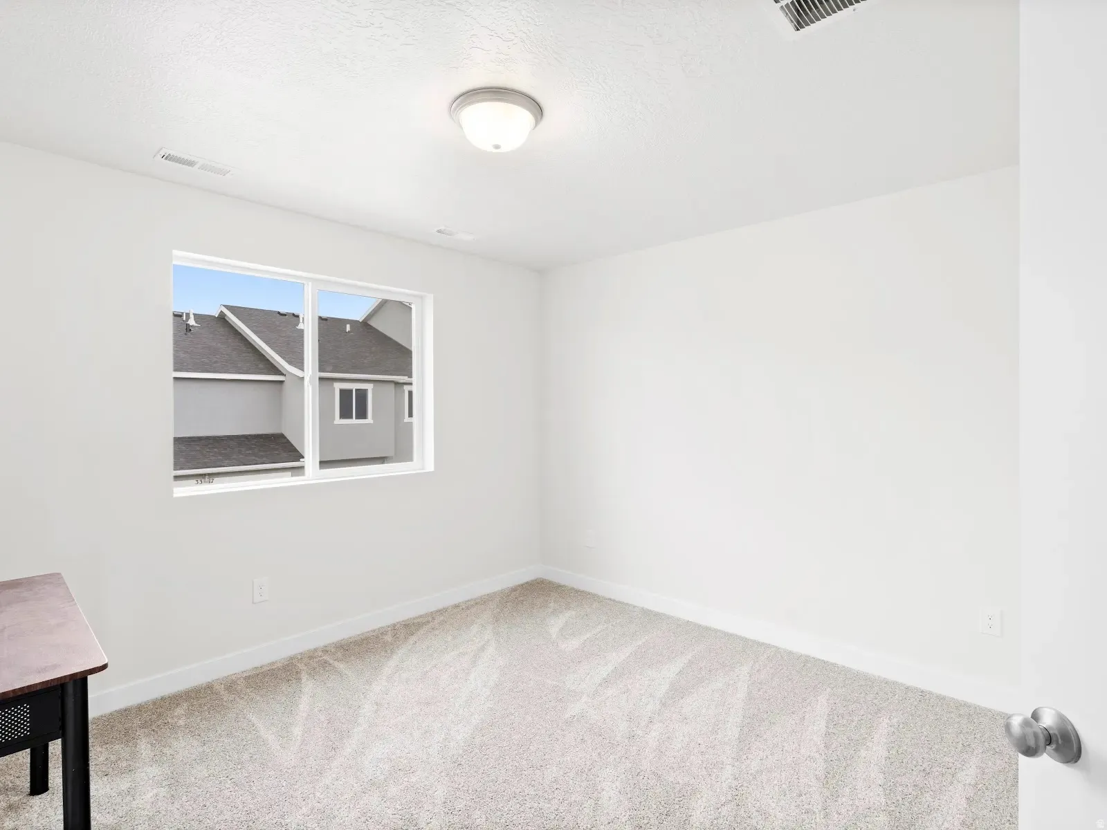Unfurnished room with light colored carpet and a textured ceiling