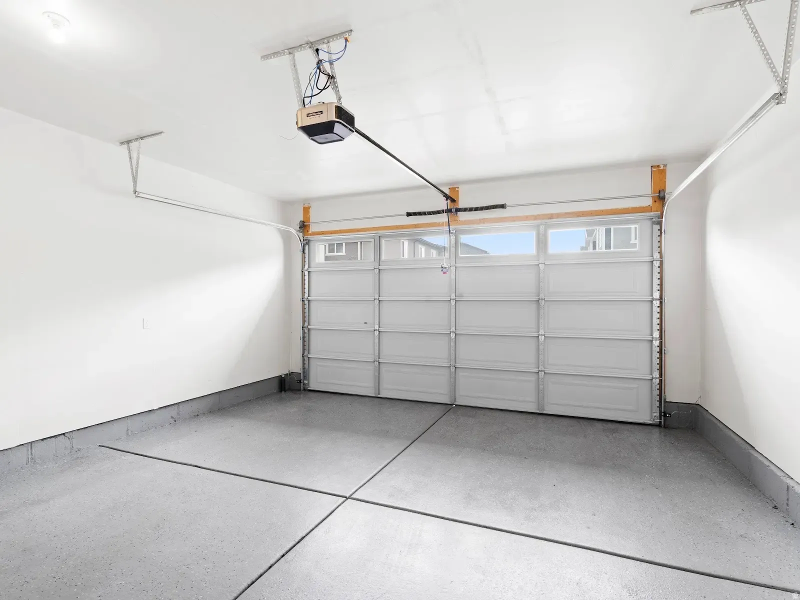 Garage with a garage door opener and baseboards