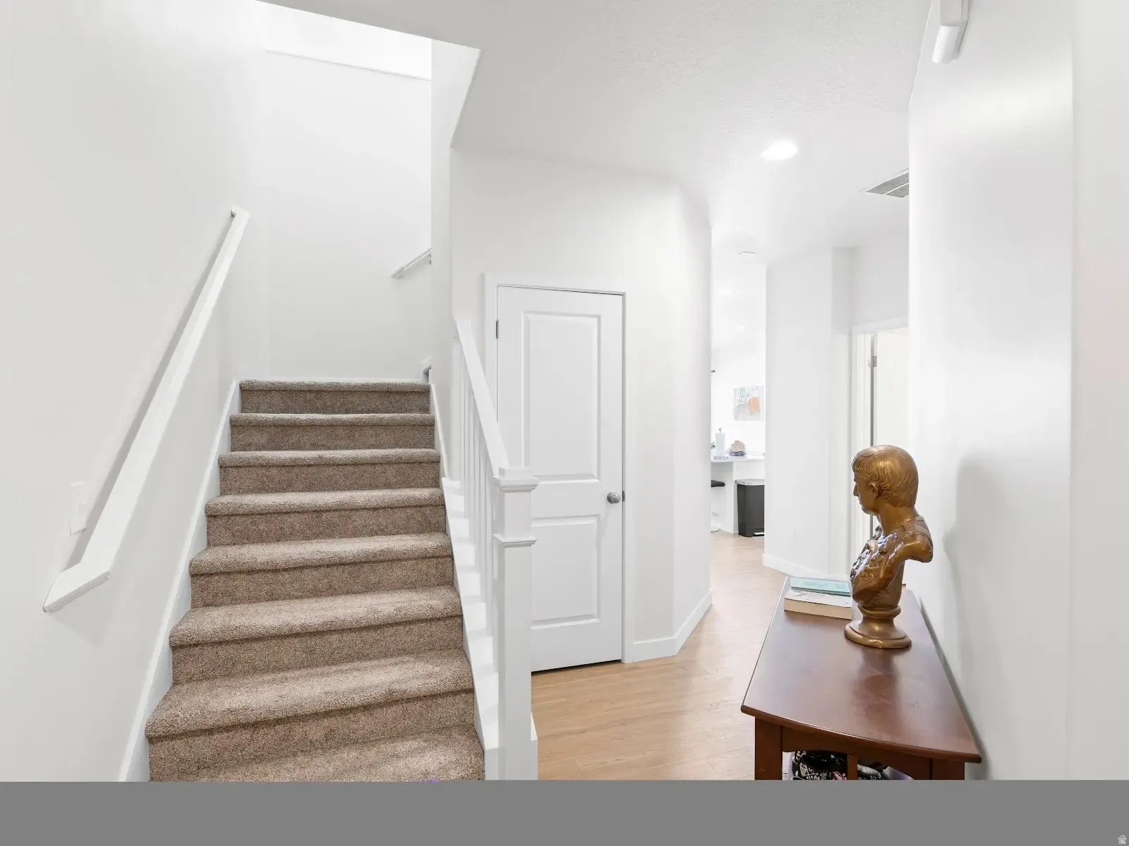 Stairway with wood finished floors and baseboards