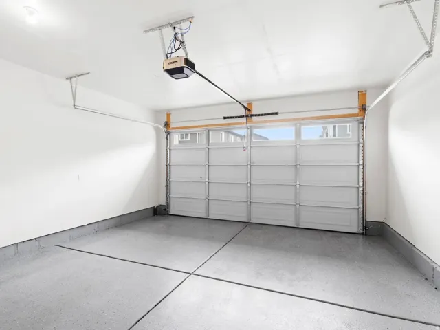 Garage with a garage door opener and baseboards