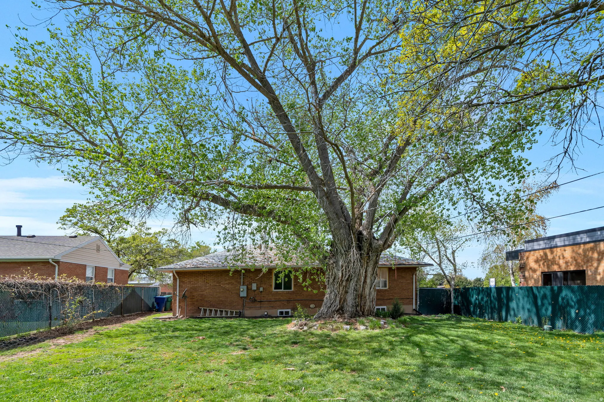 Back of house with a fenced backyard and brick siding