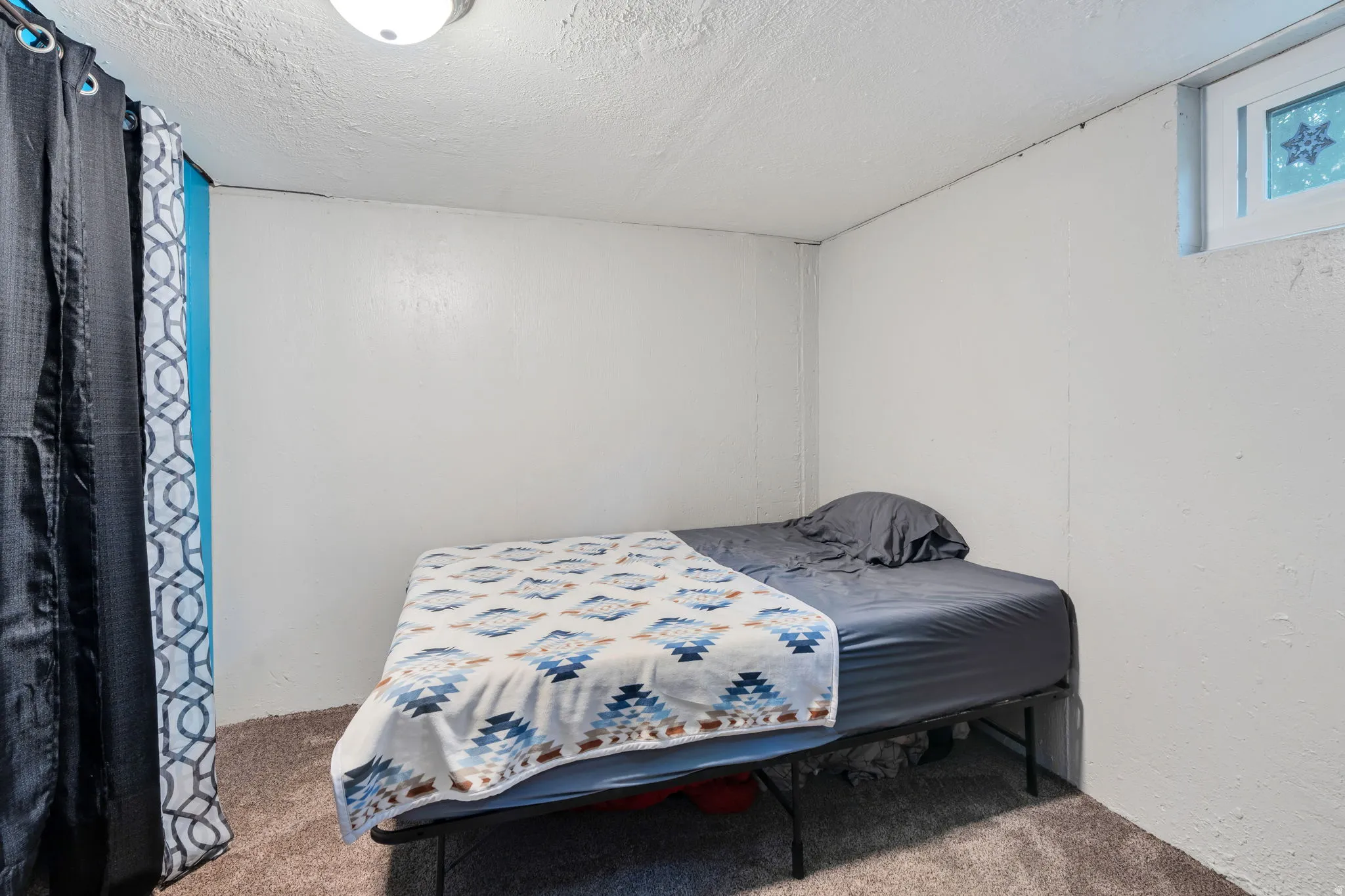 Bedroom with carpet floors and a textured ceiling