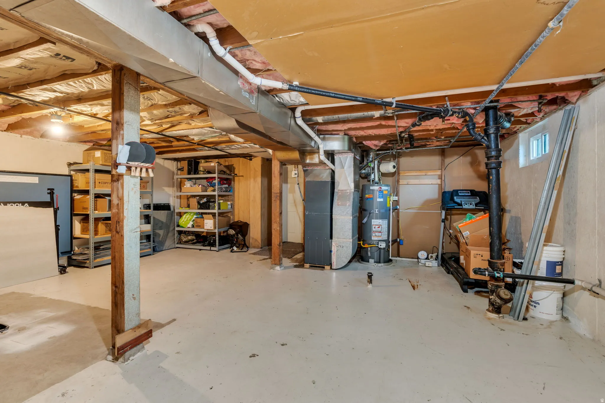 Below grade area featuring strapped water heater and heating unit