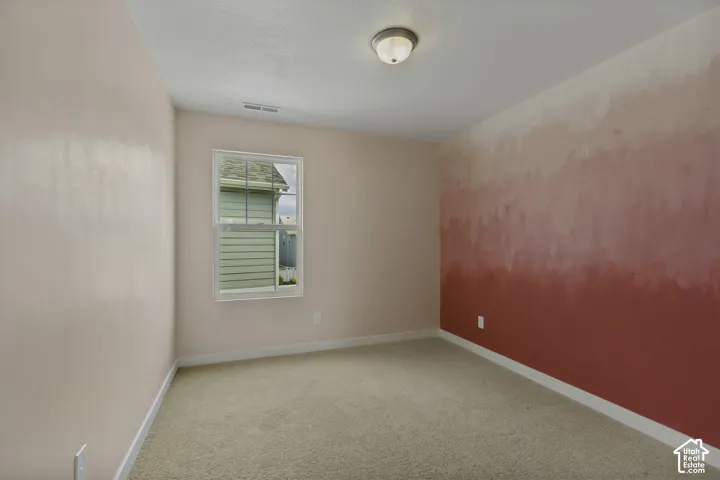 Carpeted flooring, single pane window, flush mount ceiling light, and painted walls