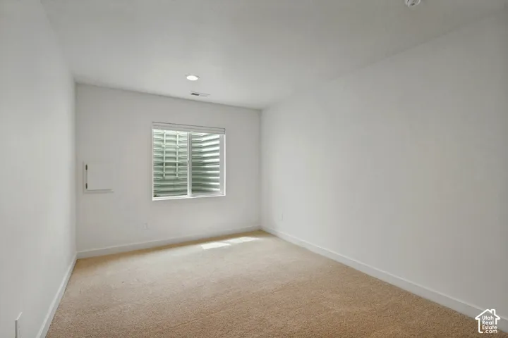 Recessed lighting, neutral carpeting, window