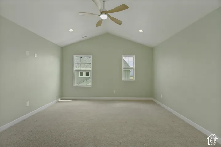 Primary bedroom suite featuring vaulted ceilings with ceiling fan, recessed lighting,