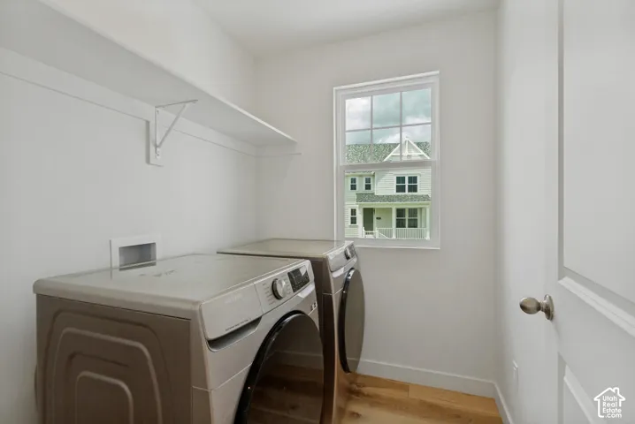 Laundry area with wood-finish flooring, white walls, and a window WASHER & DRYER INCLUDED