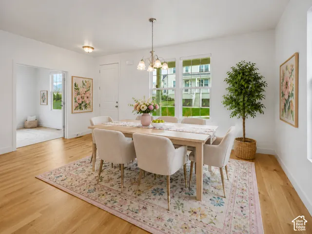 Wood-finish flooring, white walls, and a multi-light chandelier, AI staged