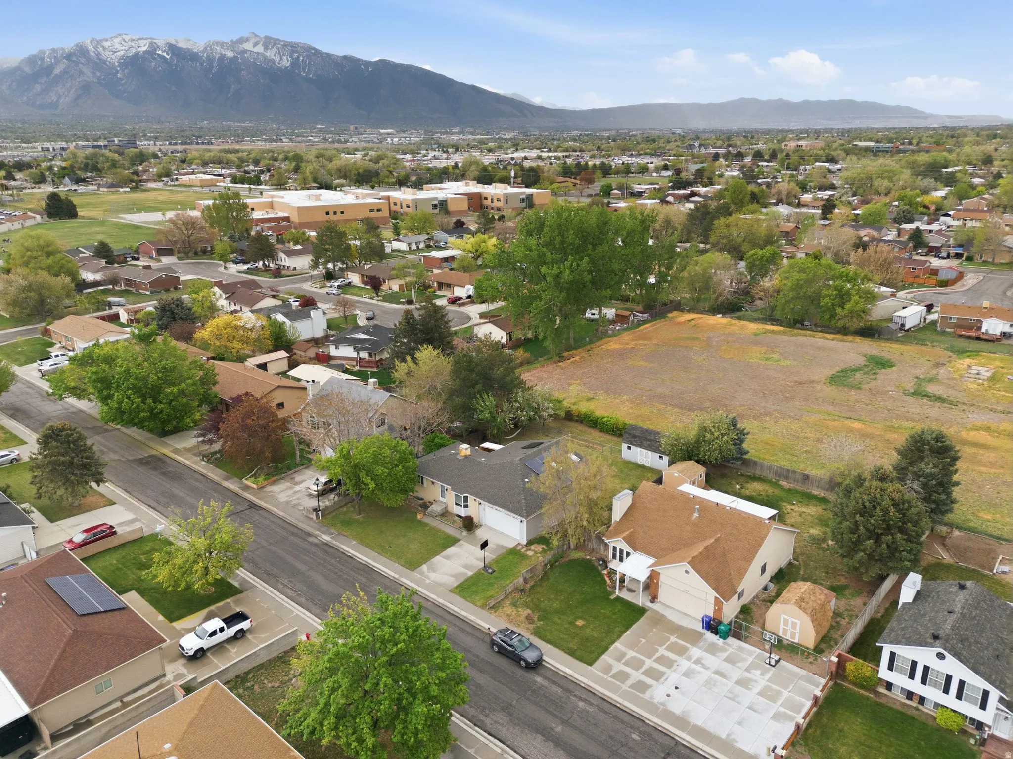 Aerial view of property and surrounding area featuring nearby suburban area and mountains