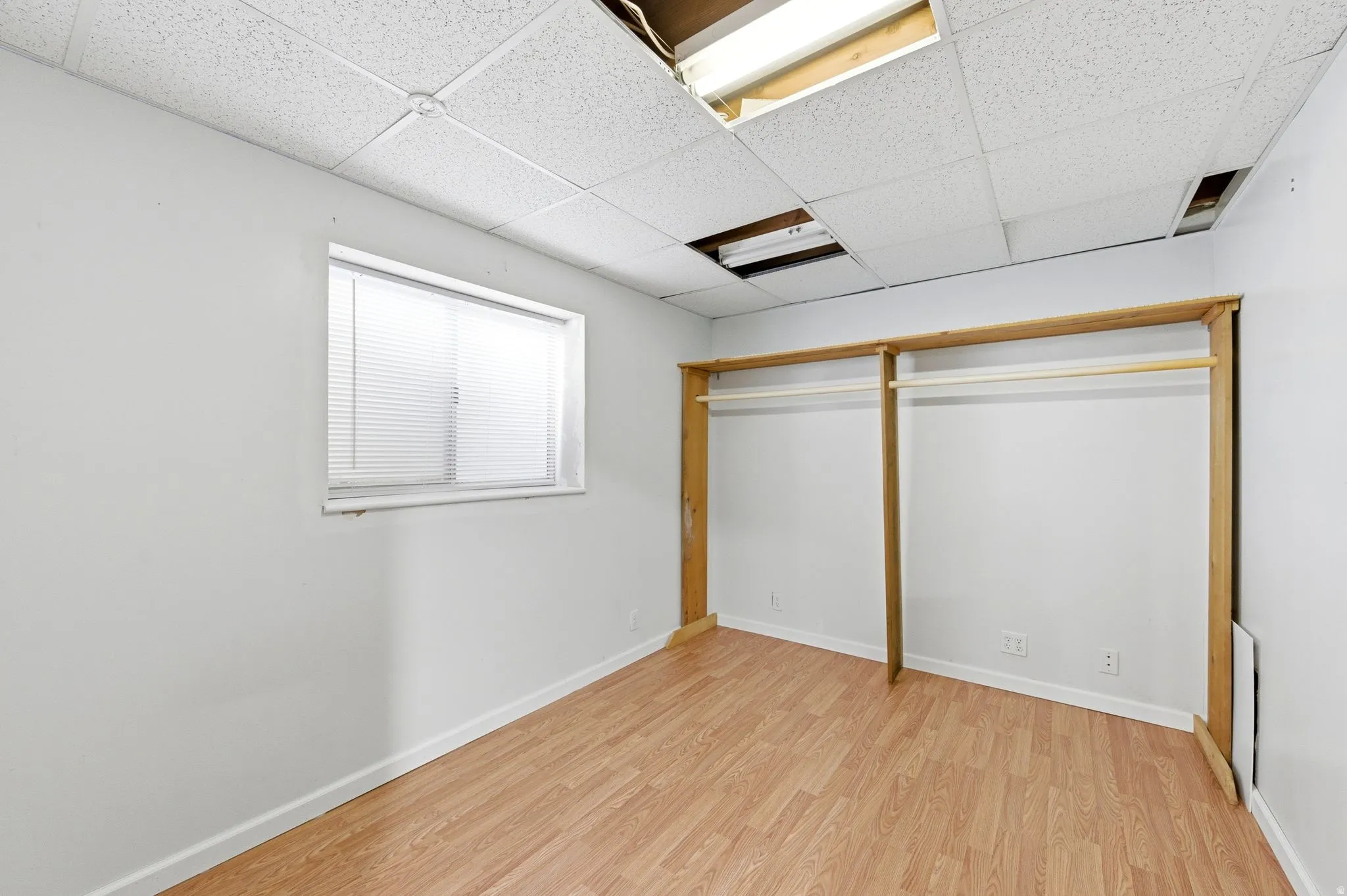 Unfurnished bedroom featuring a paneled ceiling and light wood finished floors