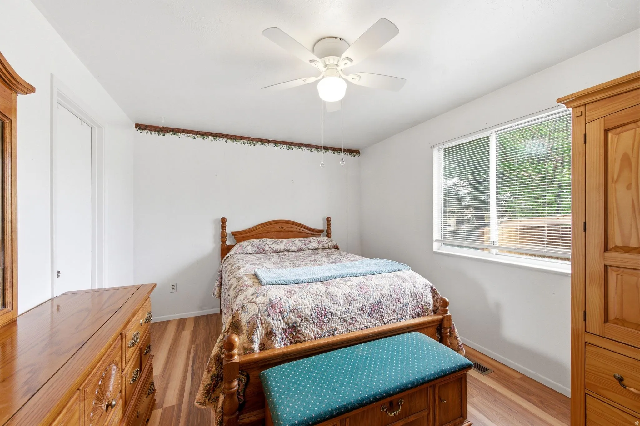 Bedroom with light wood finished floors and a ceiling fan