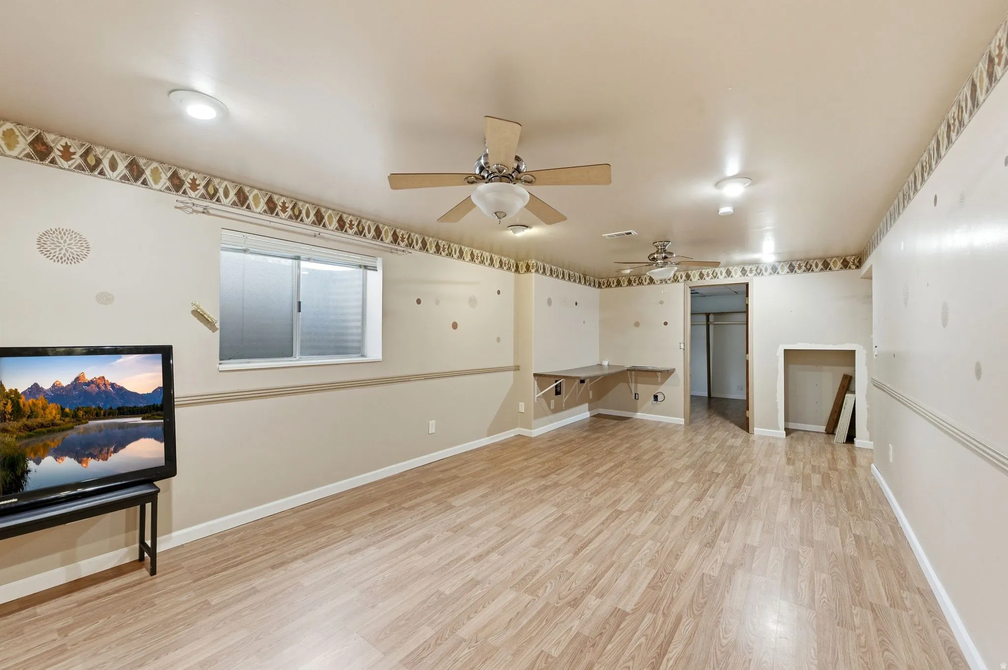 Unfurnished living room featuring light wood-type flooring and ceiling fan