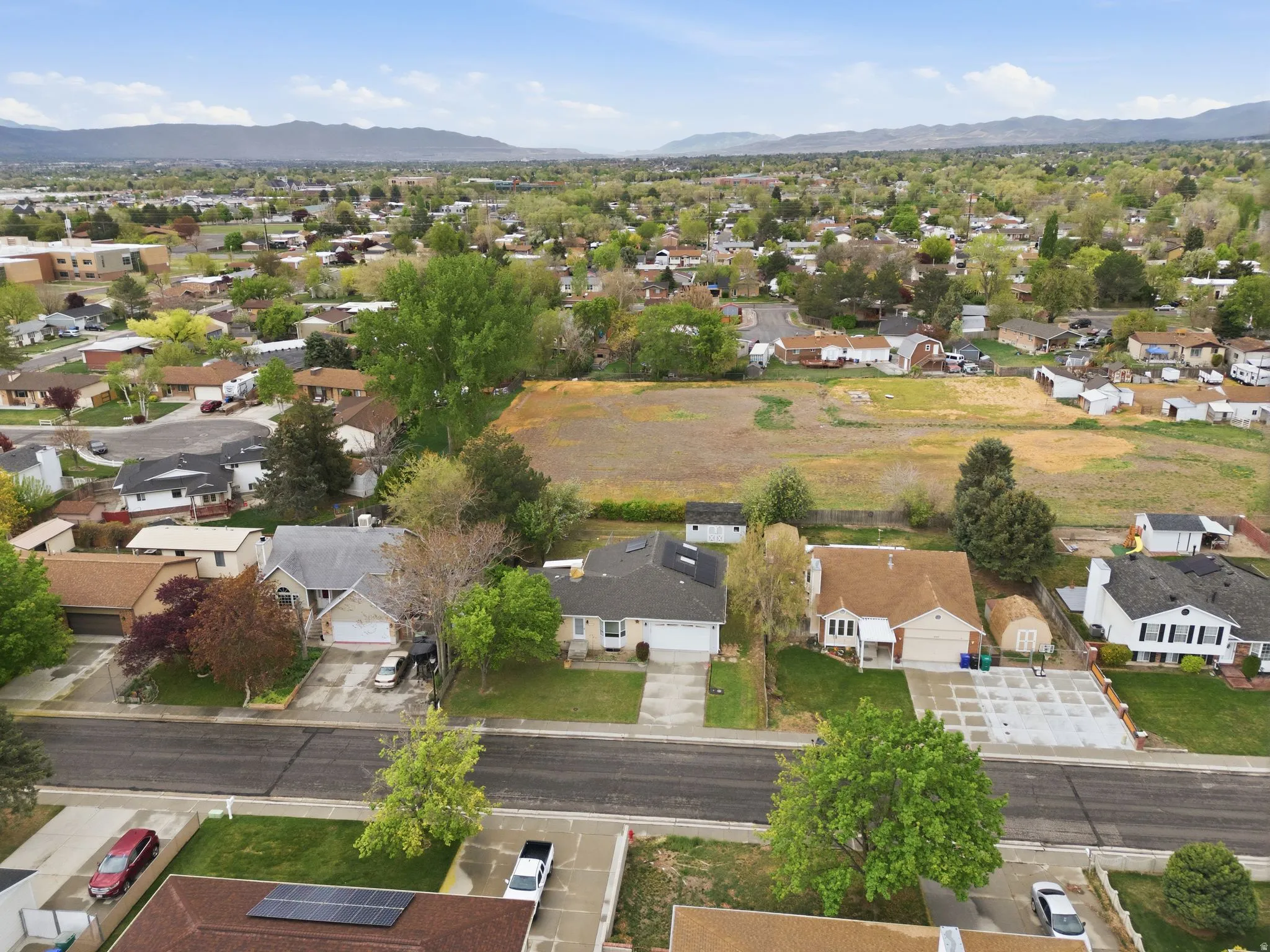 Aerial view of property and surrounding area featuring a mountain backdrop and nearby suburban area