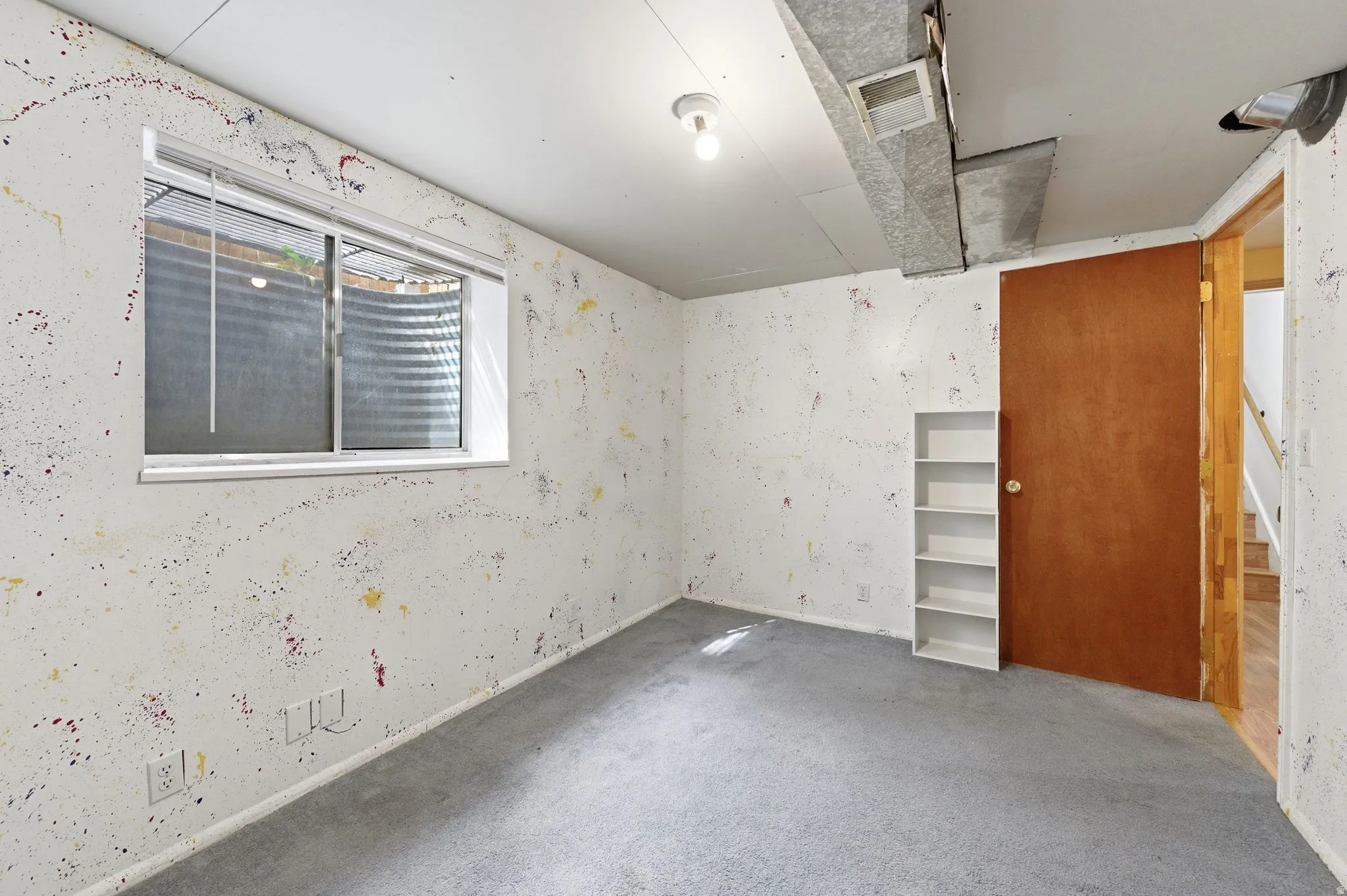 Carpeted empty room with wallpapered walls and stairway
