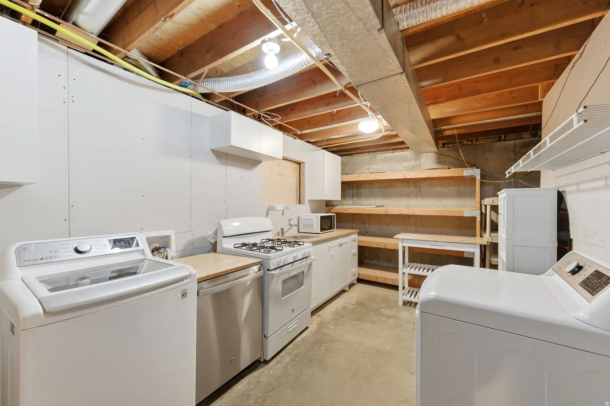 Laundry area featuring washer / dryer and unfinished concrete flooring