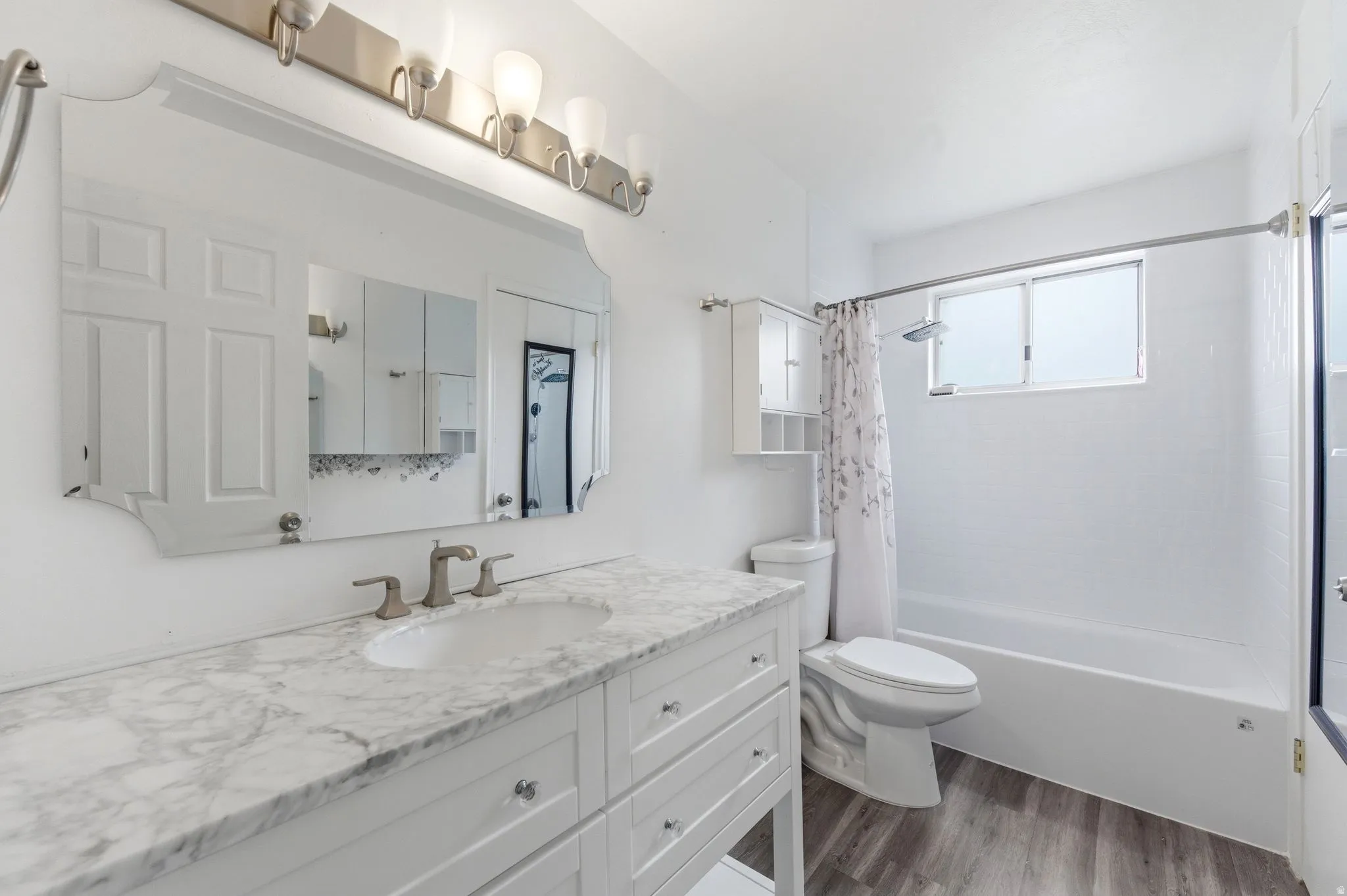 Full bath with vanity, dark wood-type flooring, and shower / bath combo with shower curtain