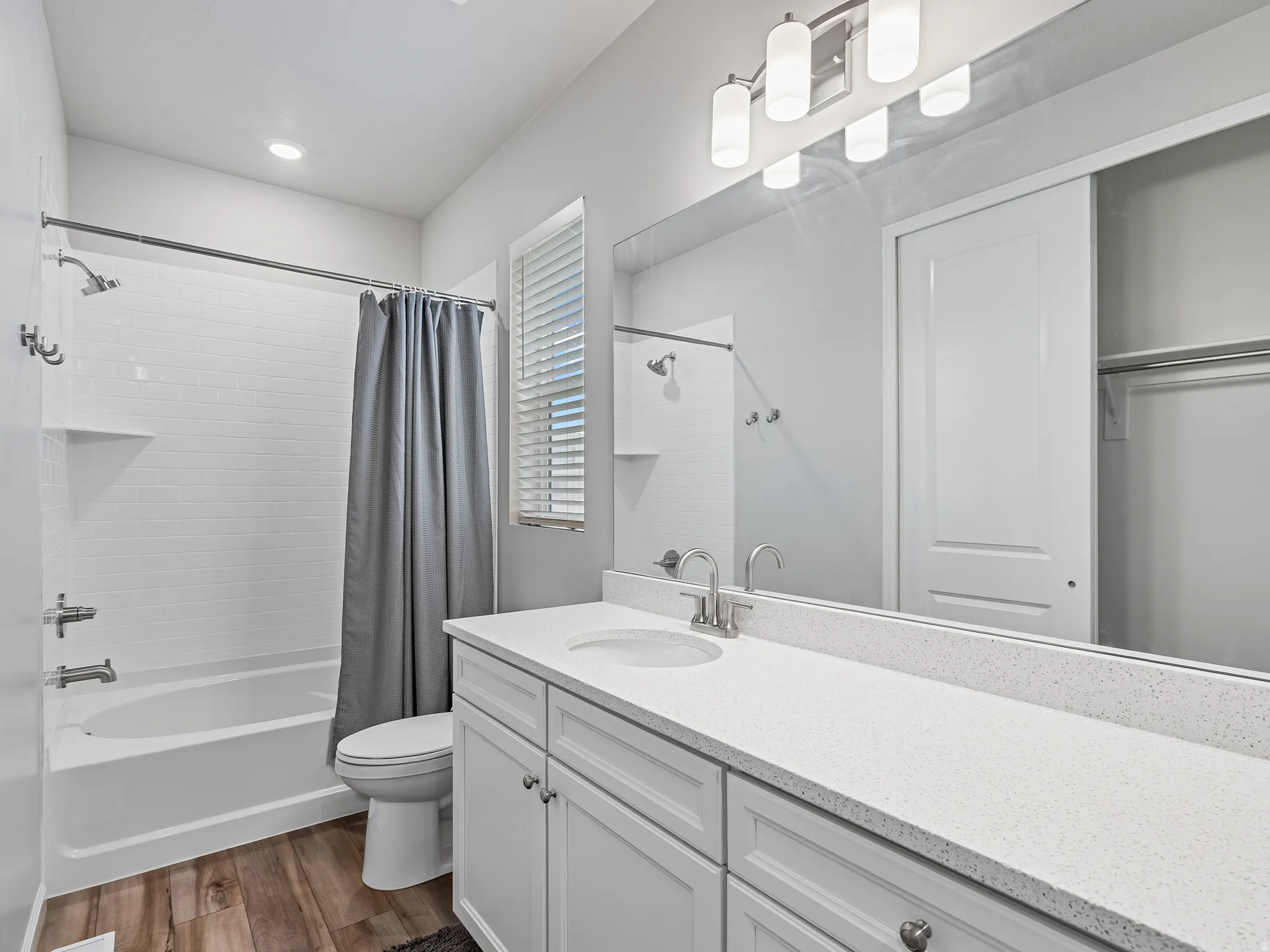 Bathroom featuring vanity, dark wood-type flooring, and shower / tub combo