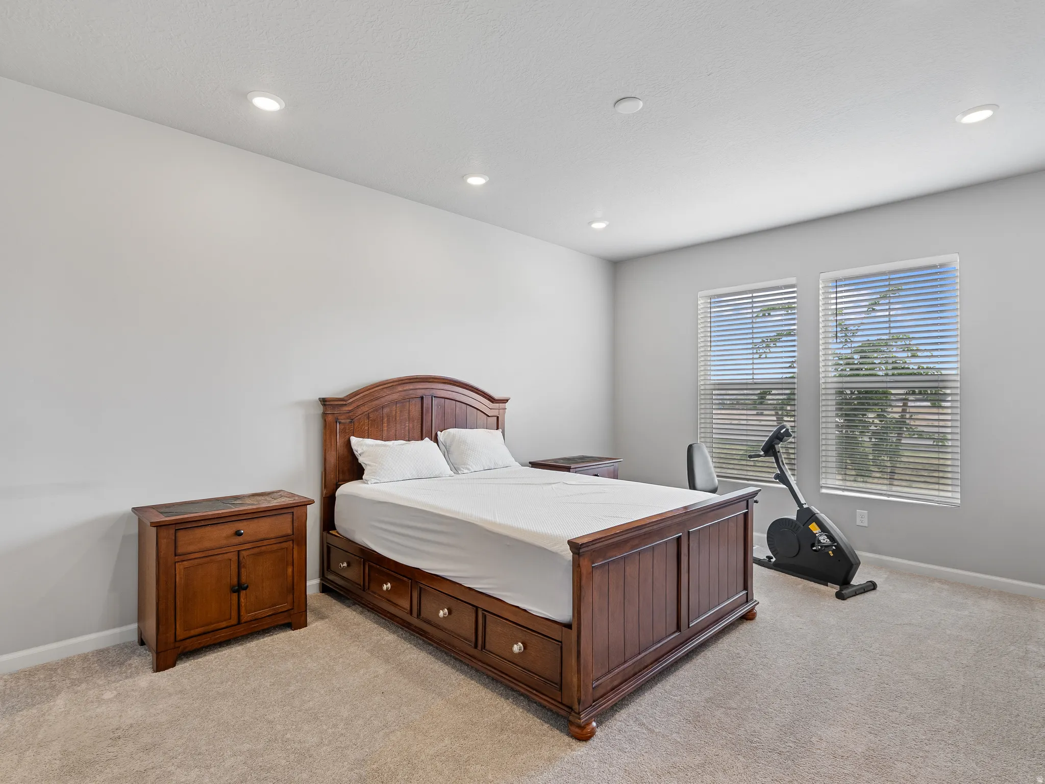 Bedroom with light colored carpet and recessed lighting