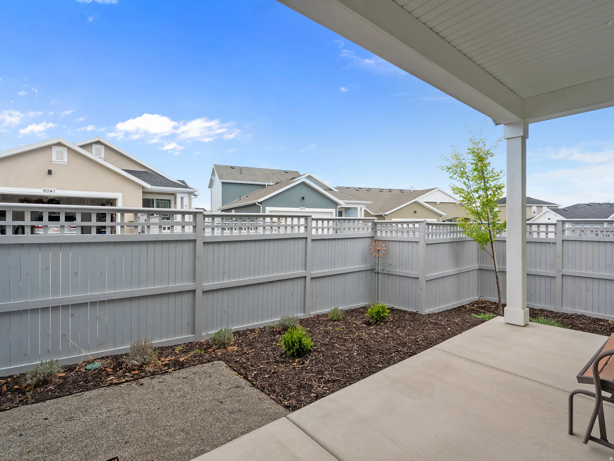 Fenced backyard with a patio area and a residential view