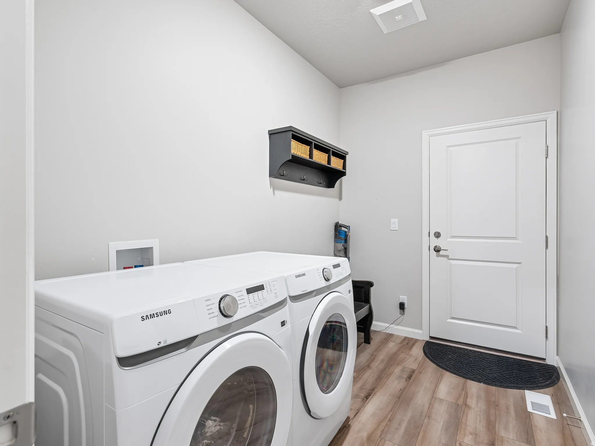 Laundry area with light wood finished floors and washer and dryer