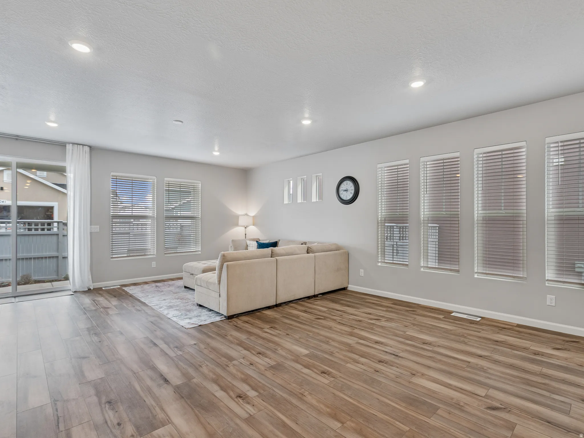 Living area with light wood-style flooring and a textured ceiling