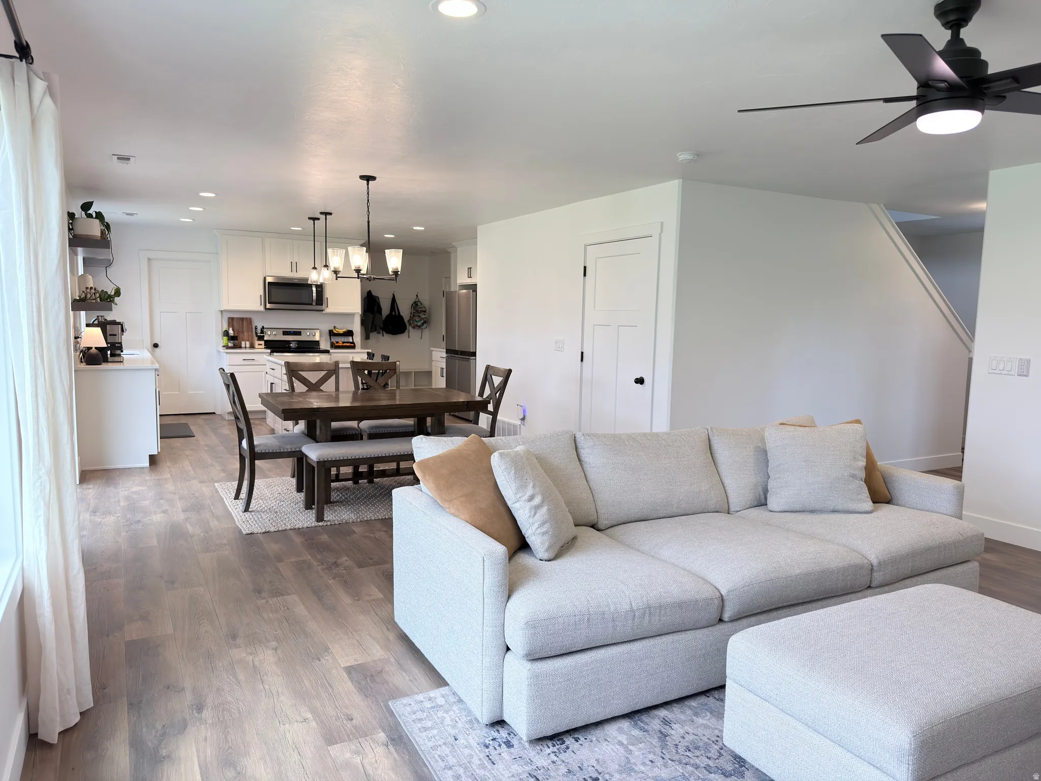 Living area featuring a ceiling fan, recessed lighting, and dark wood-style floors