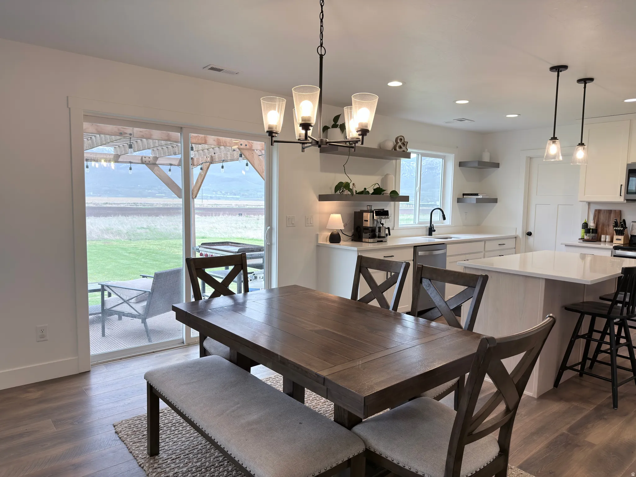 Dining area featuring suspended lighting and dark wood-style flooring