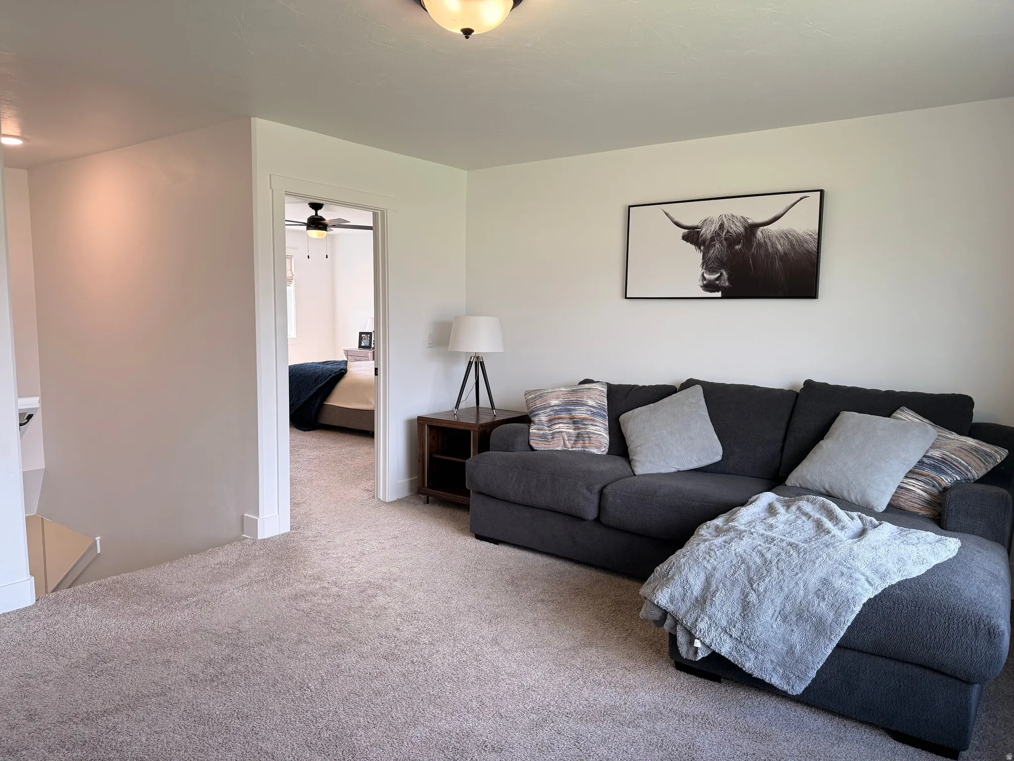 Carpeted living room with ceiling fan