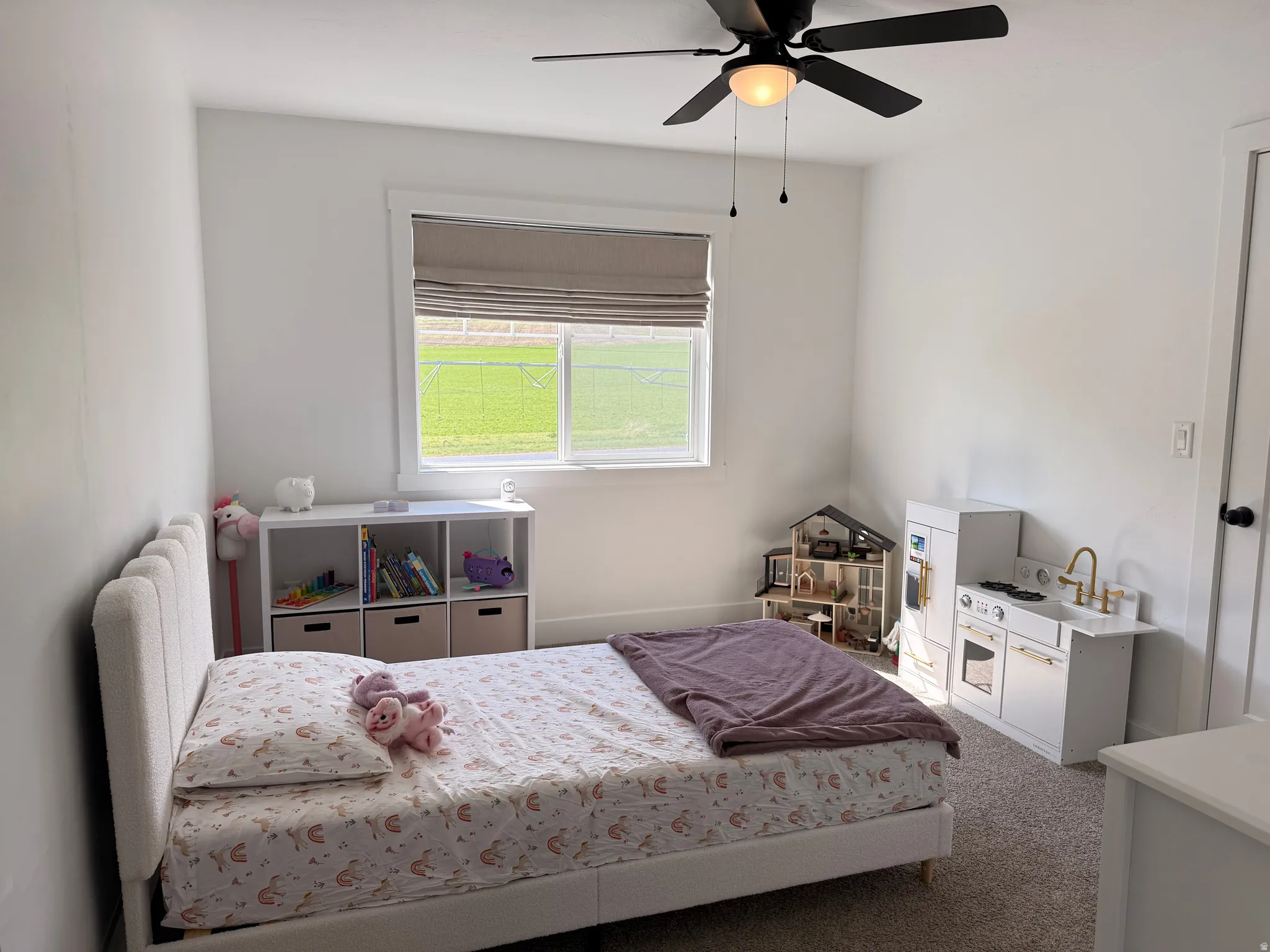 Carpeted bedroom with a ceiling fan and radiator heating unit