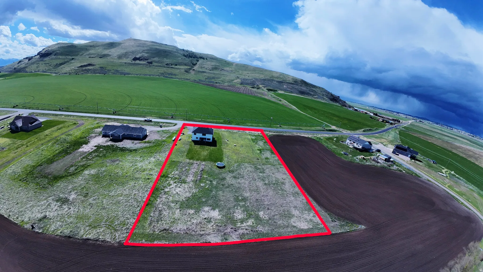 Aerial view of sparsely populated area featuring property parcel outlined and mountains
