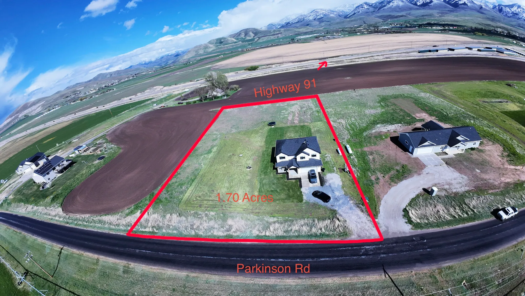 Aerial view of property and surrounding area featuring property boundaries highlighted and a mountain backdrop
